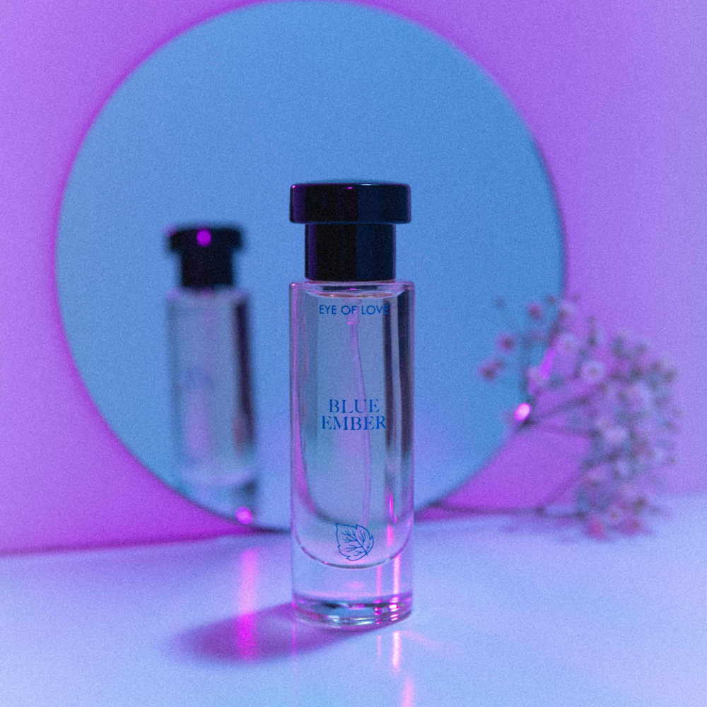 Eye of Love Bloom pheromone perfume - Blue Ember against a neon purple hue