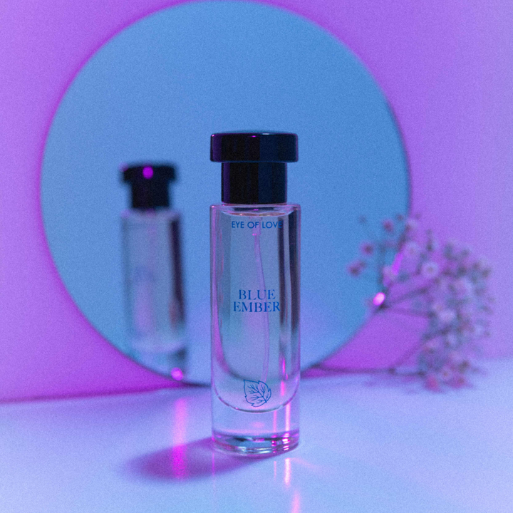 Eye of Love Bloom pheromone perfume - Blue Ember against a neon purple hue