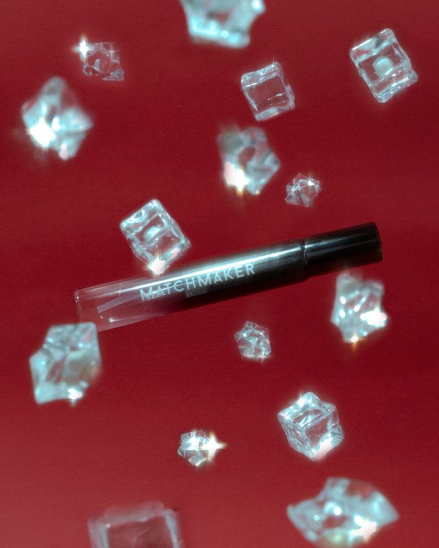 Matchmaker Black Diamond travel-sized pheromone cologne falling against a red backdrop with crystal ice cubes.