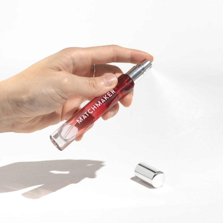 Hand holding a travel sized Eye of Love Red Diamond pheromone parfum